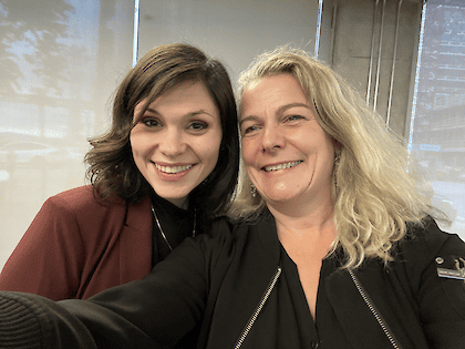 Selfie of Emma and Sarah, two women smiling closely together indoors