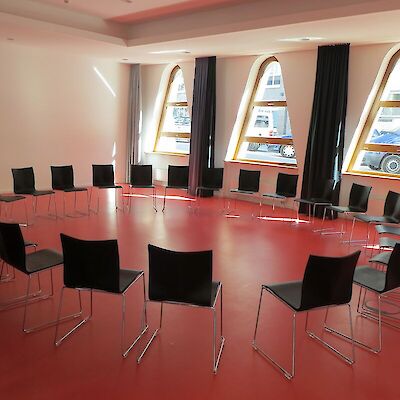 An empty room with chairs arranged in a circle for a support group meeting