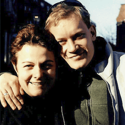 Emma and her husband Barry, smiling outdoors with their arms around each other in Boston