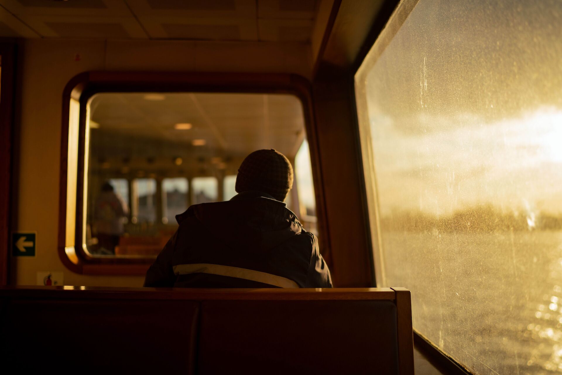 A person sitting alone on the edge of a bed in the morning light, reflecting on the grief of losing a spouse.
